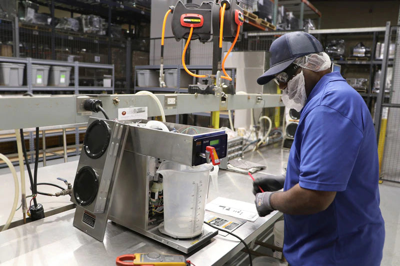 Westrock employee working on beverage equipment. Westrock is a top coffee equipment supplier.